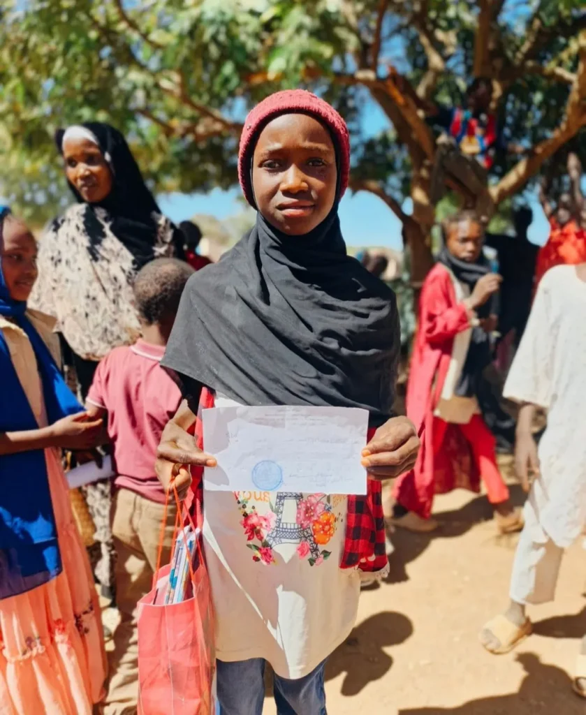 Young participant holding educational materials received through a Future Vision for Youth Empowerment education program.